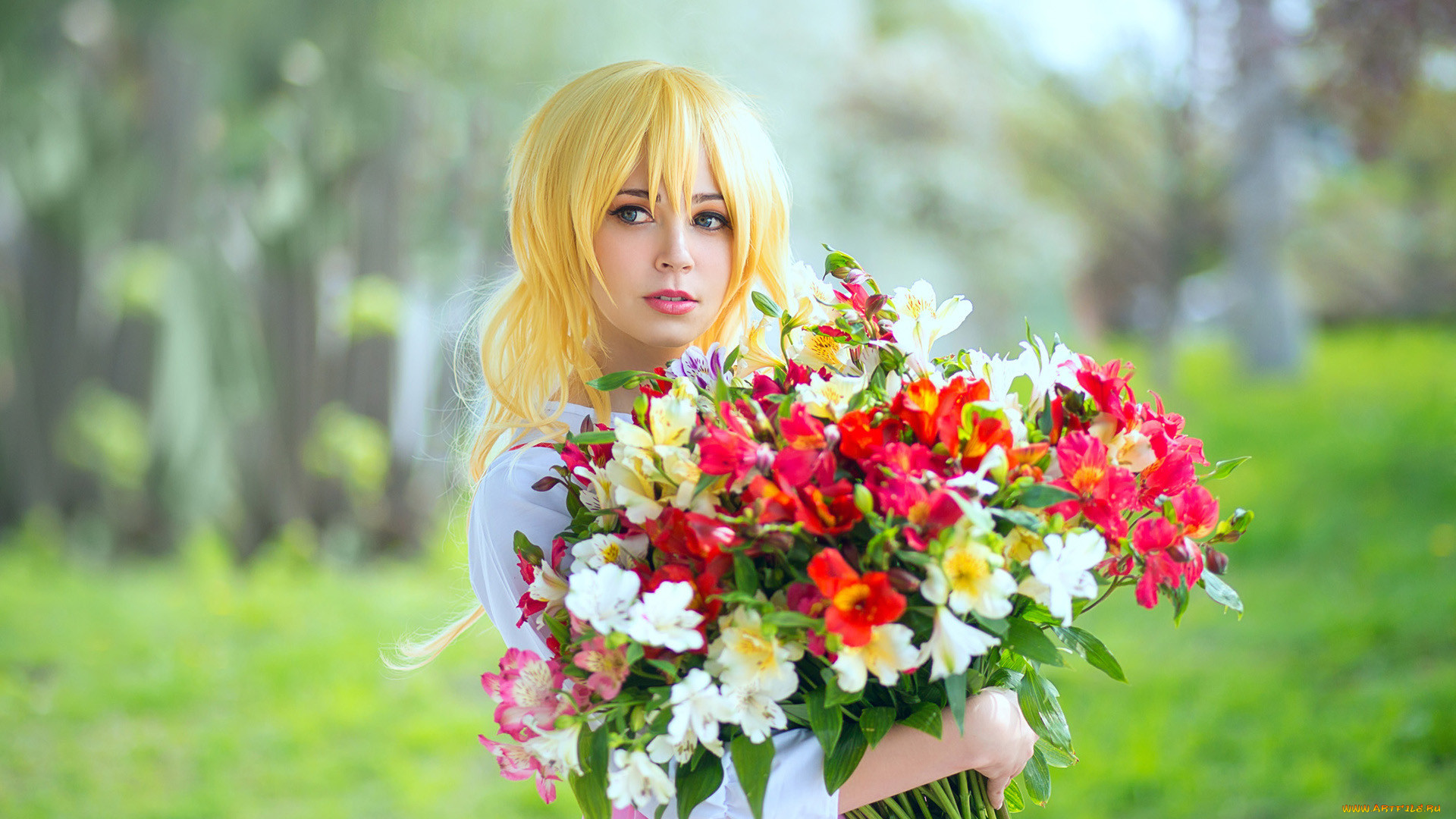 Голая блондинка с букетом цветов на берегу реки