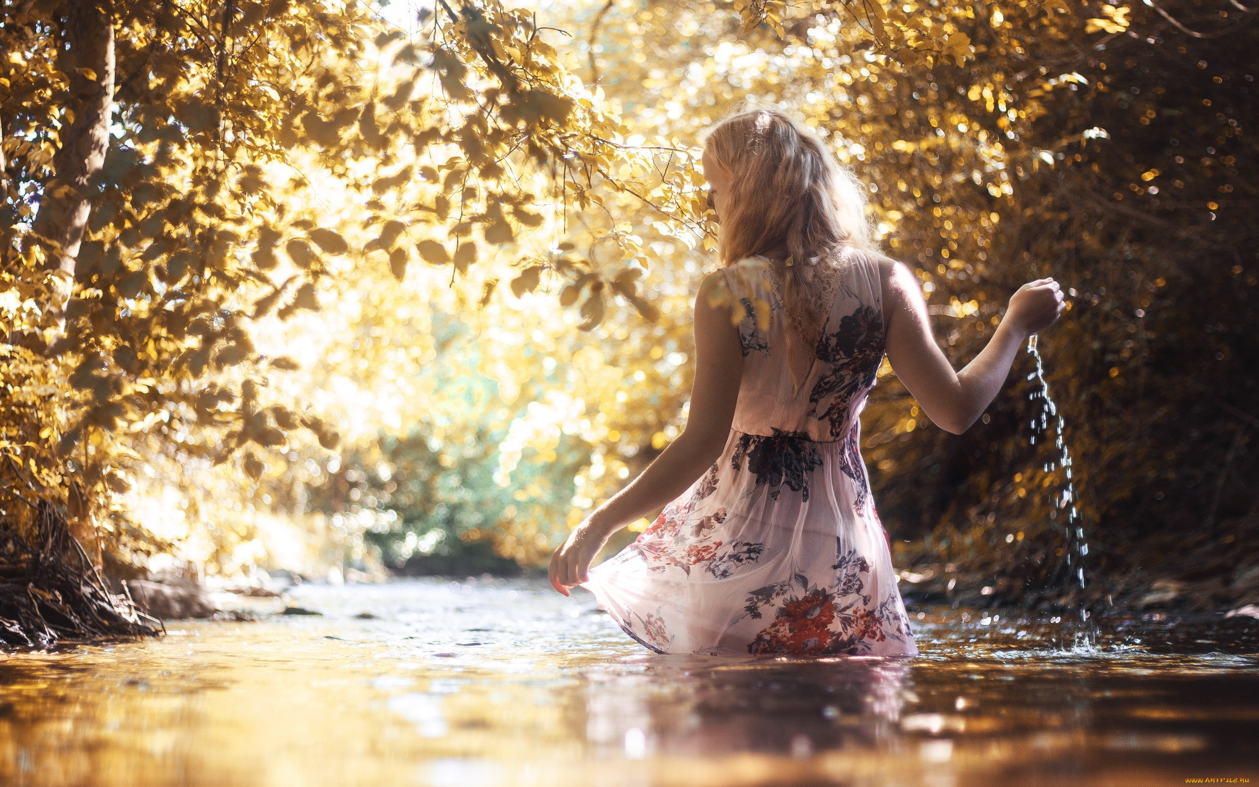 Очень красивая обнаженная блондинка с корзинкой яблок на берегу реки